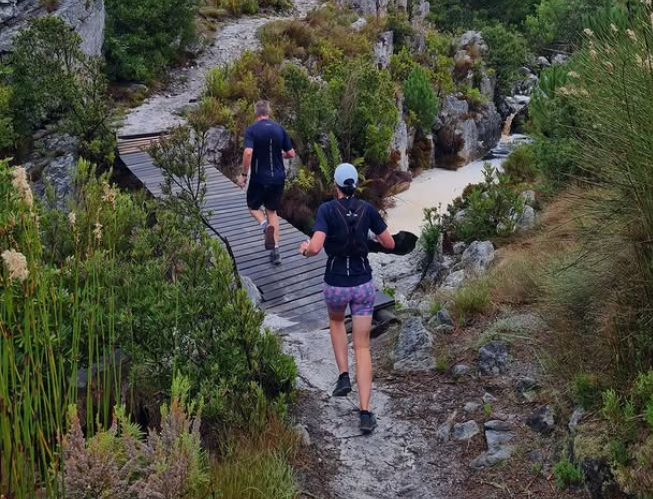 runners going over small river bridge in wilderness during the cape crusade trail